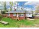 Backyard features mature trees, hot tub, and grassy lawn with wood deck at 1400 Fern Forest Dr, Gastonia, NC 28054