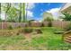 Backyard features wood deck, stairs to a grassy lawn, bench, and a wood fence at 1400 Fern Forest Dr, Gastonia, NC 28054