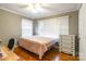 Bedroom featuring natural lighting, hardwood floors, ceiling fan, dresser storage, and neutral paint at 1400 Fern Forest Dr, Gastonia, NC 28054