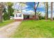Charming home with a well-manicured lawn, trees, and a combination of brick and white siding at 1400 Fern Forest Dr, Gastonia, NC 28054
