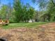 Large backyard with grass and trees, a wooden deck can be seen in the corner at 141 Hickory Creek Dr, Gastonia, NC 28052