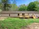 View of the back of the house with a wooden deck and grass area at 141 Hickory Creek Dr, Gastonia, NC 28052
