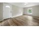 Living room featuring wood-look flooring, a window, and a white front door at 141 Hickory Creek Dr, Gastonia, NC 28052