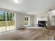 Open-concept living room with a fireplace and sliding glass doors to the deck at 141 Hickory Creek Dr, Gastonia, NC 28052