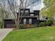 Modern two-story home with unique architectural design, a well-manicured lawn, and mature trees at 1437 Jules Ct, Charlotte, NC 28226
