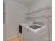 Bright laundry room features a modern washer and dryer with wire shelving for optimal storage solutions at 1437 Jules Ct, Charlotte, NC 28226