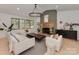 Bright living room with stone fireplace, elegant chandelier, neutral furniture, and large windows at 1437 Jules Ct, Charlotte, NC 28226