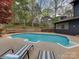 Backyard view of a pool, deck, and black house, surrounded by mature trees at 1437 Jules Ct, Charlotte, NC 28226