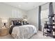 Stylish bedroom with patterned bedding, side table, and window with decorative curtains at 1471 Hubert Graham Way, Tega Cay, SC 29708