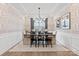 Elegant dining room featuring wainscoting, patterned wallpaper, and modern chandelier over a wood table at 1471 Hubert Graham Way, Tega Cay, SC 29708