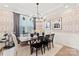 Elegant dining room boasts a rustic wooden table with black chairs, set against patterned wallpaper at 1471 Hubert Graham Way, Tega Cay, SC 29708