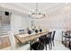 Modern dining area featuring a wooden table, stylish black chairs, and eye-catching chandelier and wallpaper at 1471 Hubert Graham Way, Tega Cay, SC 29708