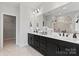 Primary bathroom with double vanity, black fixtures, a large mirror, and a glass-enclosed shower at 1471 Hubert Graham Way, Tega Cay, SC 29708
