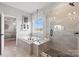Primary bathroom featuring a soaking tub, glass-enclosed shower, and linen storage at 1471 Hubert Graham Way, Tega Cay, SC 29708