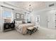 Primary bedroom with decorative ceiling, chandelier, bedside tables, and an ensuite bathroom at 1471 Hubert Graham Way, Tega Cay, SC 29708