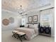 Primary bedroom with decorative ceiling, chandelier, bedside tables, and plenty of natural light at 1471 Hubert Graham Way, Tega Cay, SC 29708