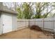 Enclosed backyard with a concrete patio, white fence, and exterior access door at 1532 Hunt Club Ct, Rock Hill, SC 29732