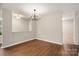 Open dining room with hardwood floors, modern chandelier, and neutral paint creating an elegant space at 1532 Hunt Club Ct, Rock Hill, SC 29732