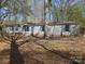 Charming single-story home featuring blue shutters and mature trees at 1586 Brook Ln, Denver, NC 28037