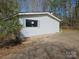 View of back of home and driveway with white siding and blue shutters at 1586 Brook Ln, Denver, NC 28037
