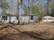 Charming exterior view of a house with blue shuttered windows and overgrown trees at 1586 Brook Ln, Denver, NC 28037