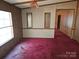 Photo of a living room featuring dated paneling and red carpets at 1586 Brook Ln, Denver, NC 28037