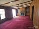 Living room featuring a stone fireplace and built-in shelves with outdated carpet at 1586 Brook Ln, Denver, NC 28037