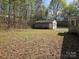 View of a detached garage, with overgrown grass, and tree surround at 1586 Brook Ln, Denver, NC 28037