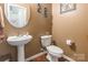 Half bathroom with modern sink, toilet, wood floors, and neutral wall color at 16431 Leavitt Ln, Davidson, NC 28036