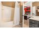 Bathroom boasting a white tub/shower combo and a view of a bedroom with red walls at 16431 Leavitt Ln, Davidson, NC 28036