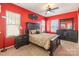 Bedroom with red walls, ceiling fan, and dark wood furniture at 16431 Leavitt Ln, Davidson, NC 28036