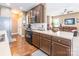 Well-lit kitchen with stainless steel appliances, brown cabinetry, and a view into the living room at 16431 Leavitt Ln, Davidson, NC 28036