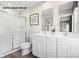 Well-lit bathroom featuring double sinks, white cabinetry, a glass-enclosed shower, and modern fixtures at 169 Basildon St # 1012, Lancaster, SC 29720