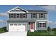 Charming two-story home featuring a two-car garage, red front door, and blue siding with black shutters at 169 Basildon St # 1012, Lancaster, SC 29720