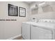 Functional laundry room with white washer and dryer, shelving for storage, and modern decor at 169 Basildon St # 1012, Lancaster, SC 29720