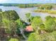 Aerial view of a house near a lake surrounded by lush trees, showcasing the tranquility of the waterfront property at 1720 Gaither Rd, Belmont, NC 28012