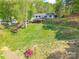 Expansive backyard featuring a grassy lawn, mature trees and a raised deck at 1720 Gaither Rd, Belmont, NC 28012