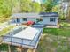 Backyard showcasing a large deck, blooming flowers, and mature trees, highlighting the outdoor living space at 1720 Gaither Rd, Belmont, NC 28012