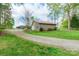 Exterior view of the home and detached garage, featuring a gravel driveway and a well-maintained lawn at 1720 Gaither Rd, Belmont, NC 28012