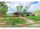 Charming exterior view of a single-story home with a well-manicured lawn, trees and a path to the front door at 1720 Gaither Rd, Belmont, NC 28012
