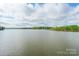 Expansive view of a serene lake under a partly cloudy sky, showcasing the beauty of the waterfront property at 1720 Gaither Rd, Belmont, NC 28012