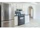 Kitchen with stainless steel refrigerator, black oven, white cabinets, and archway to another room at 1805 Lawton Dr, Rock Hill, SC 29730