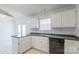 Well-lit kitchen with white cabinets, a black dishwasher, and a view of the backyard through patio doors at 1805 Lawton Dr, Rock Hill, SC 29730