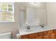 Bright bathroom featuring double sinks, a large mirror, and a window for natural light at 18838 Oakhurst Blvd, Cornelius, NC 28031