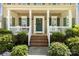 Inviting front porch with classic details, white railings, and a decorative wreath on the front door at 18838 Oakhurst Blvd, Cornelius, NC 28031