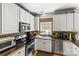 Well-lit kitchen features stainless steel appliances, mosaic backsplash, and ample cabinet space for storage at 18838 Oakhurst Blvd, Cornelius, NC 28031