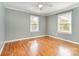 Serene bedroom featuring hardwood floors, soft gray walls, and natural light from dual windows at 1926 Coley Sw St, Concord, NC 28027