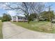 Charming home featuring a well-maintained lawn, mature trees, and a long driveway leading to the front entrance at 1926 Coley Sw St, Concord, NC 28027