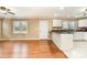 Open-concept living area with hardwood floors seamlessly transitioning into the kitchen and dining space at 1926 Coley Sw St, Concord, NC 28027