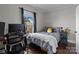 Modern bedroom featuring hardwood floors, a comfortable bed, and a functional workspace area at 207 Kerr Nw St, Concord, NC 28025